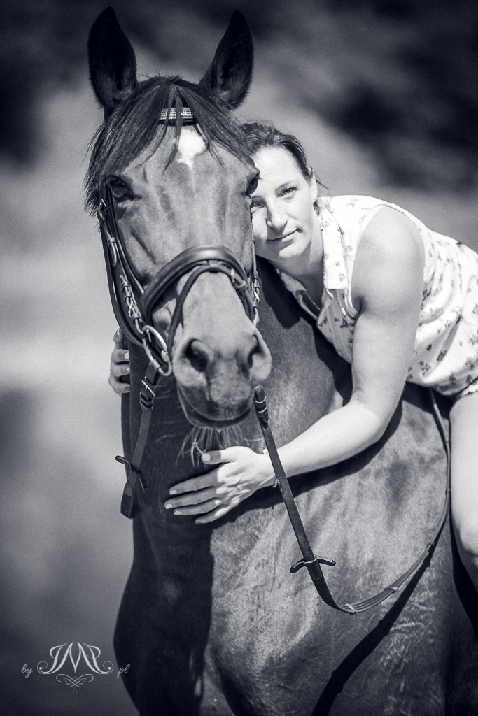 kobieta przytulająca się do szyi konia czarno-białe zdjęcie