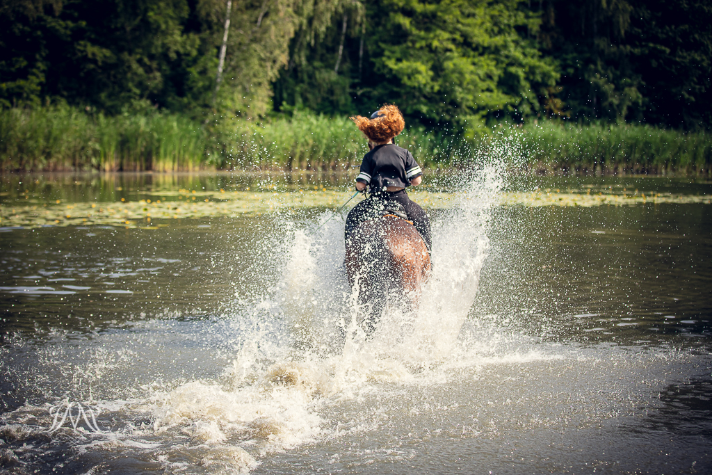 rudowłosa dziewczyna wjeżdżająca do jeziora na koniu